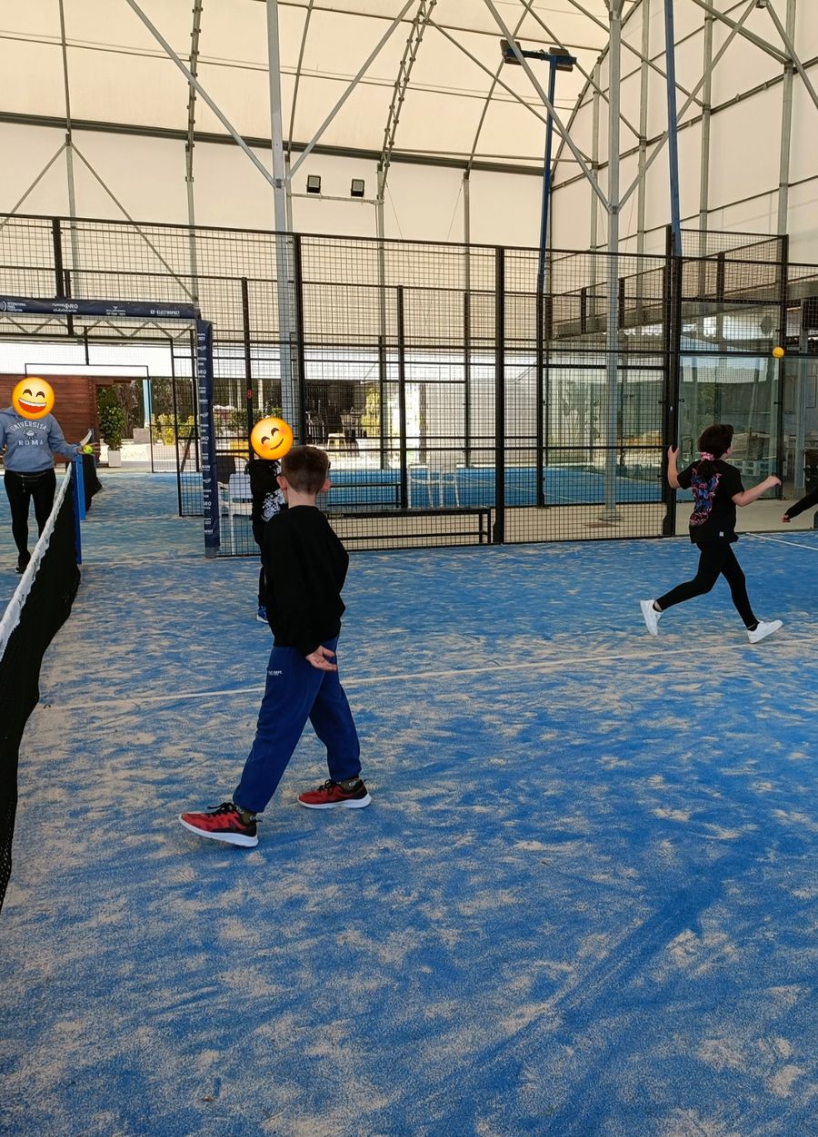 Escolares jugando un partido en la pista de pádel cubierta